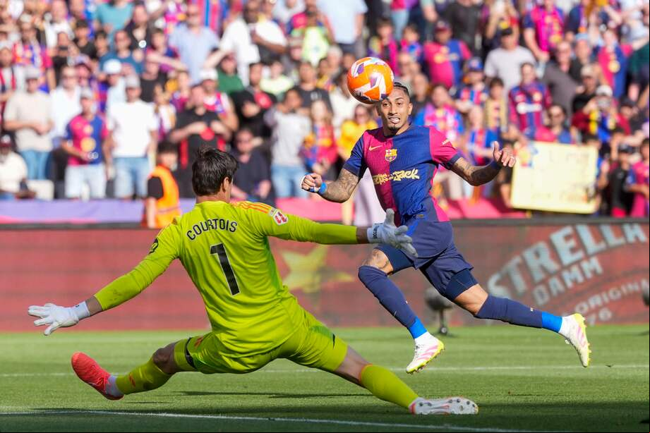 BARCELONA, 11/05/2025.-El delantero del Barcelona Raphinha, y el portero del Real Madrid Thibaut Courtois, durante el partido de la jornada 35 de LaLiga EA Sports entre el Barcelona y el Real Madrid, este domingo en el Estadi Olímpic Lluís Companys.-EFE/ Siu Wu